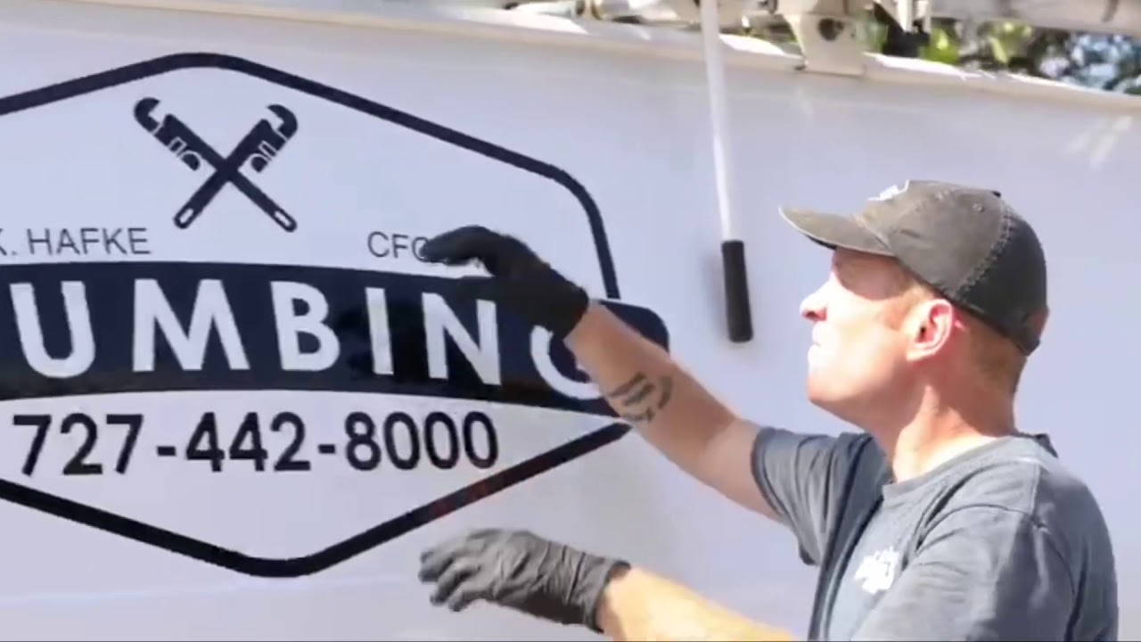 Hafke Plumbing team member beside a branded service vehicle